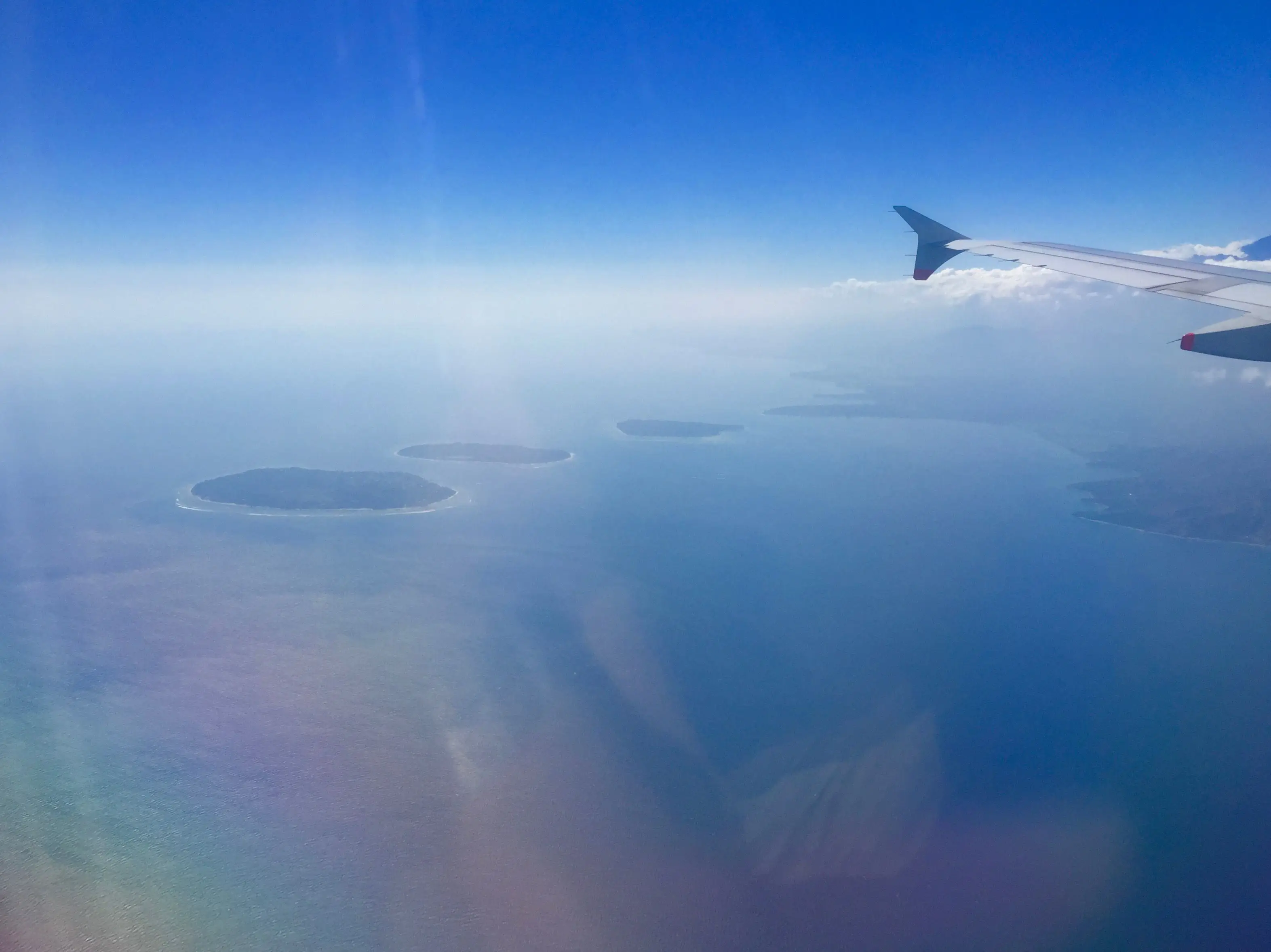 Gili-Inseln und die Küste Lomboks unter einer Flugzeugtragfläche