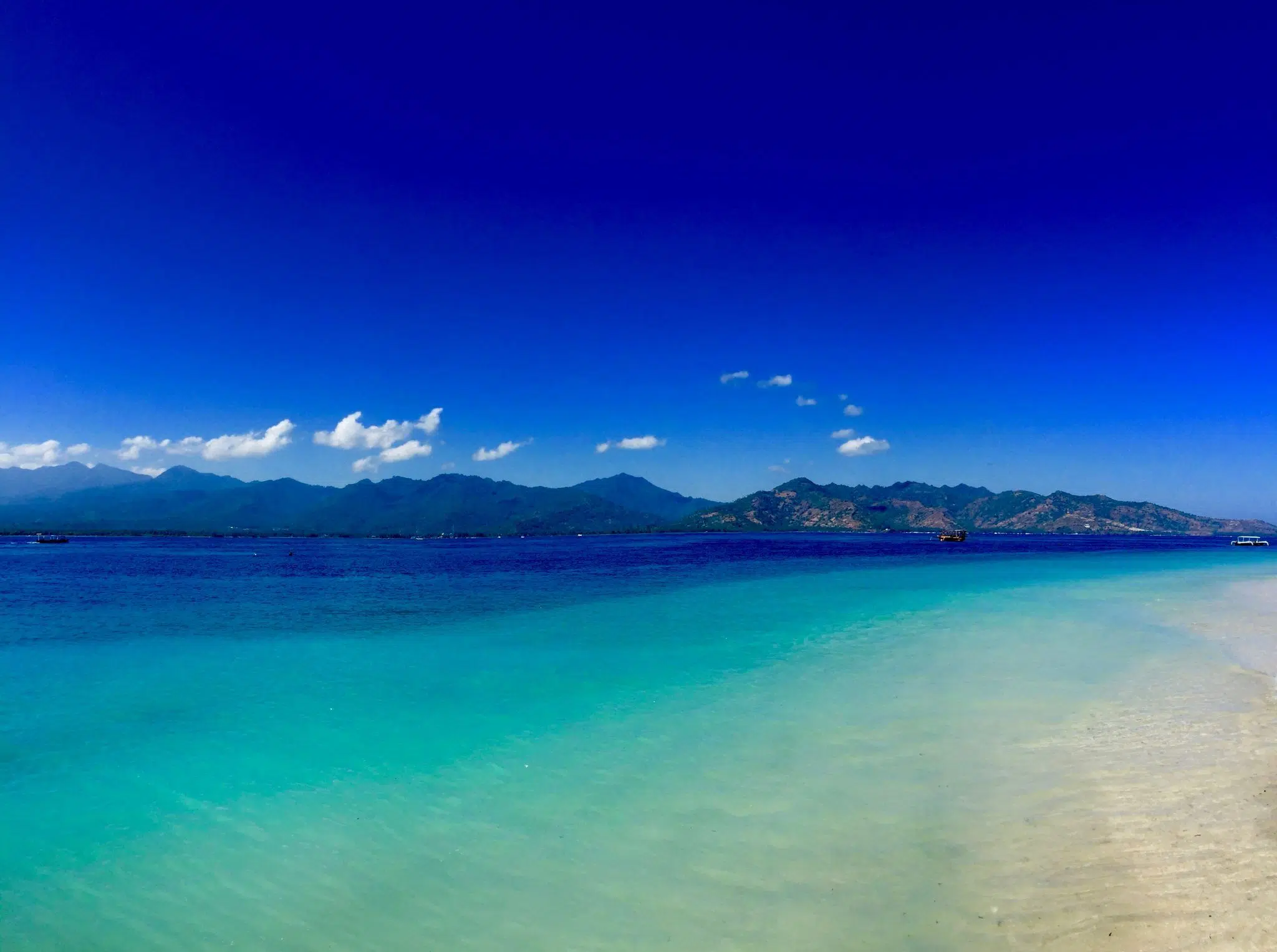 Anreise auf die Gili-Inseln: Bali oder Lombok? 3 Blick von einer Gili-Insel über türkisfarbenes Wasser nach Lombok