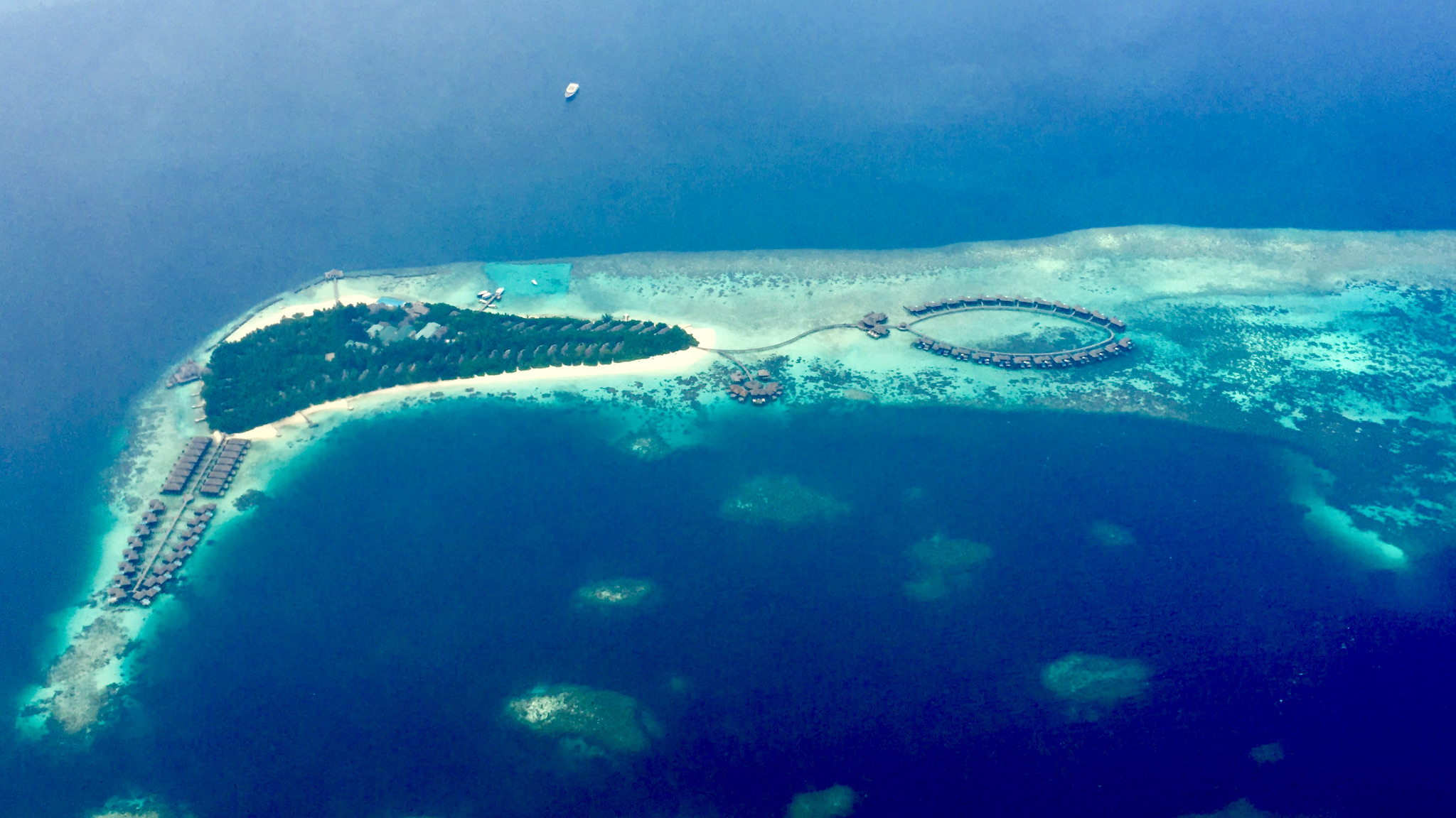 Luftaufnahme einer Malediven-Resortinsel: typisch sind die auf Stegen in die Lagune gebauten Water Villas. Foto: Sascha Tegtmeyer