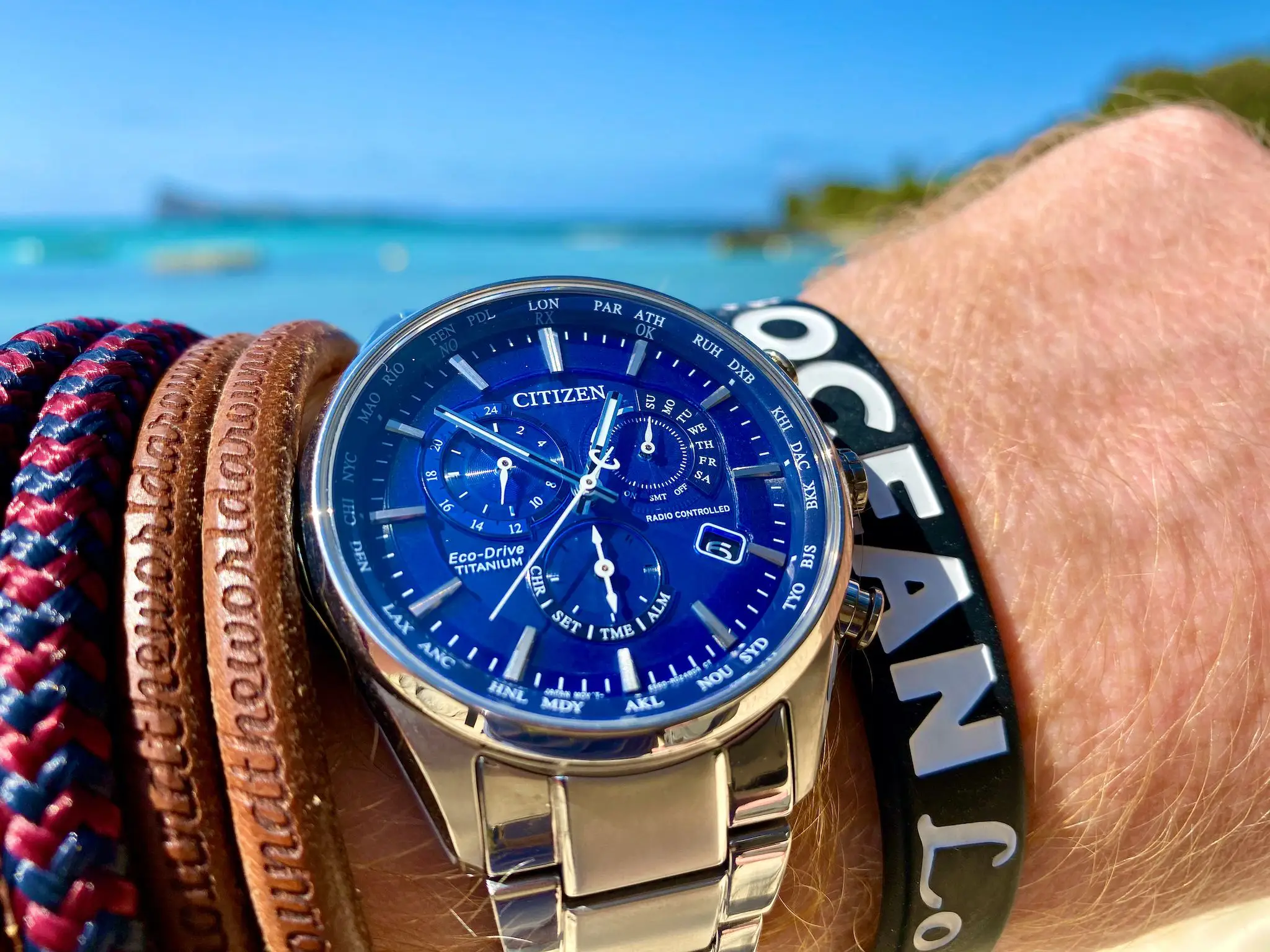 Taucheruhr kaufen: Worauf Taucher wirklich achten sollten 3 Citizen Eco-Drive Titanium mit blauem Zifferblatt am Handgelenk an einem tropischen Strand