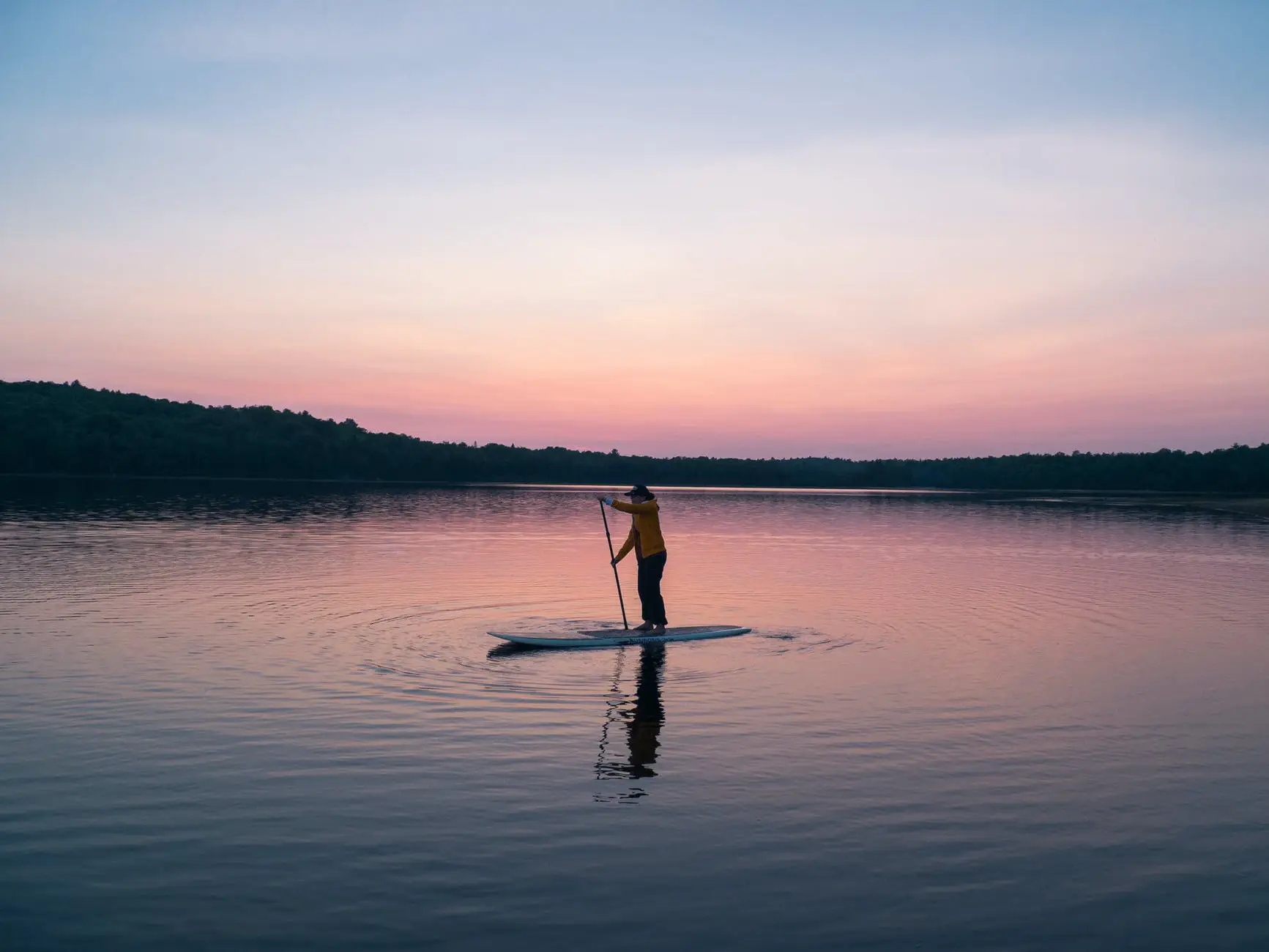 Nachhaltig SUP fahren: 15 Tipps für Board und Natur 2 Stand-up-Paddler mit einem festen SUP-Board auf ruhigem Wasser