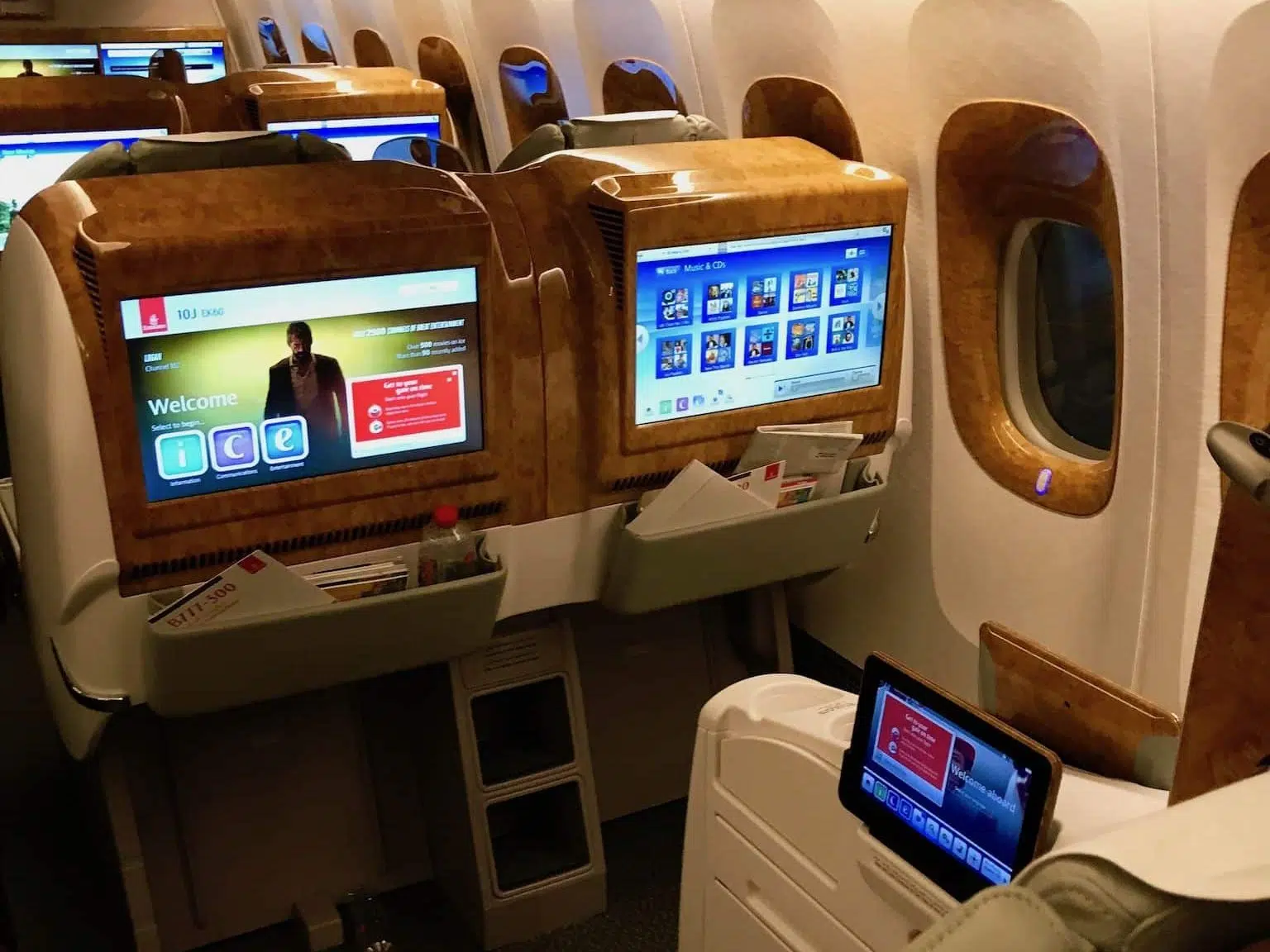 Flugreisen-Tipps: Entspannt von der Buchung bis zur Ankunft 4 Breite Flugzeugsitze mit großen Bildschirmen in einer Emirates-Business-Class-Kabine