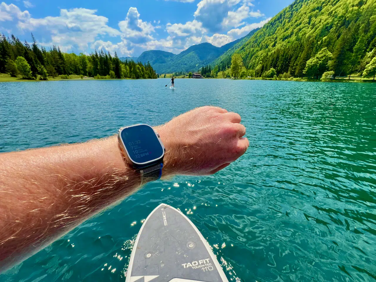 Sportuhren – Tests, Auswahlhilfe & Erfahrungen 5 Apple Watch Ultra an Saschas Hand über einem SUP-Board auf dem Pillersee