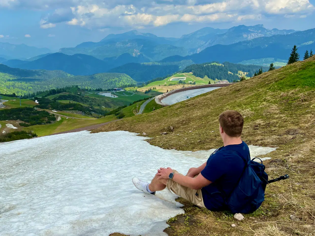 Apple Watch beim Wandern: Erfahrungen, Offline-Karten und Akku 8 Sascha sitzt mit Apple Watch neben einem Schneefeld über einem Bergtal