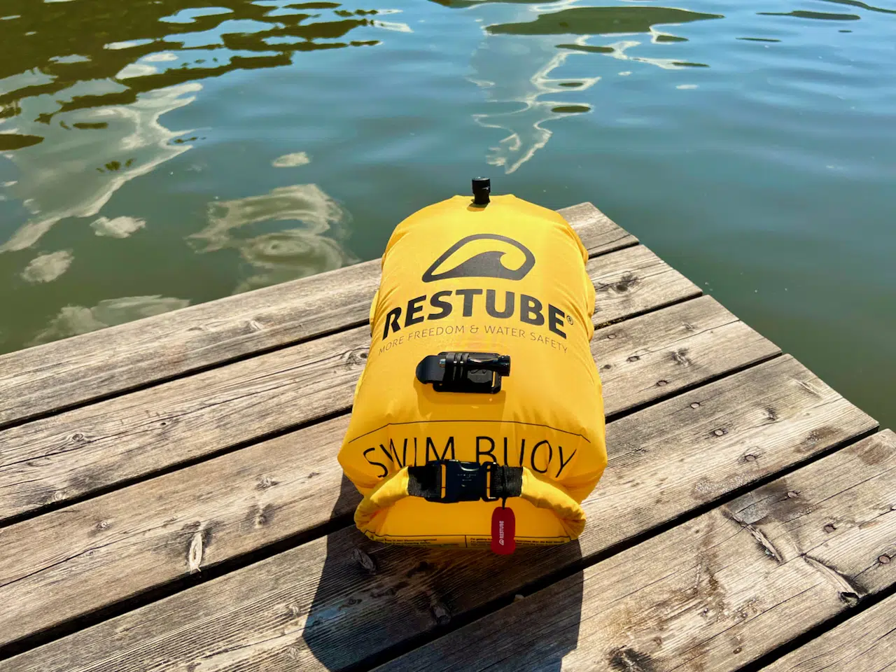 Mein Sicherheits-Setup für SUP und Freiwasser: Was ich wirklich mitnehme 3 Aufgeblasene gelbe Restube Swim Buoy Pro auf einem Holzsteg am See