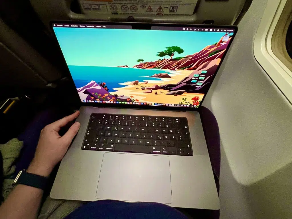 Technische Ausrüstung auf Reisen: Was du wirklich brauchst 7 Laptop auf einem Tisch vor grüner Vegetation