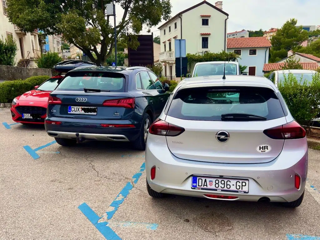 Mietwagen auf Krk: Erfahrungen, Parken und 4 Routen 8 Autos auf blau markierten kostenpflichtigen Parkflächen auf Krk