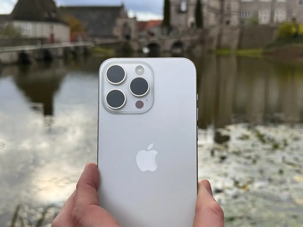 iPhone 15 Pro Max Test: meine Erfahrungen auf Reisen und Kaufcheck 2026 11 Rückseite eines iPhone 15 Pro Max in Naturtitan vor einem Schloss