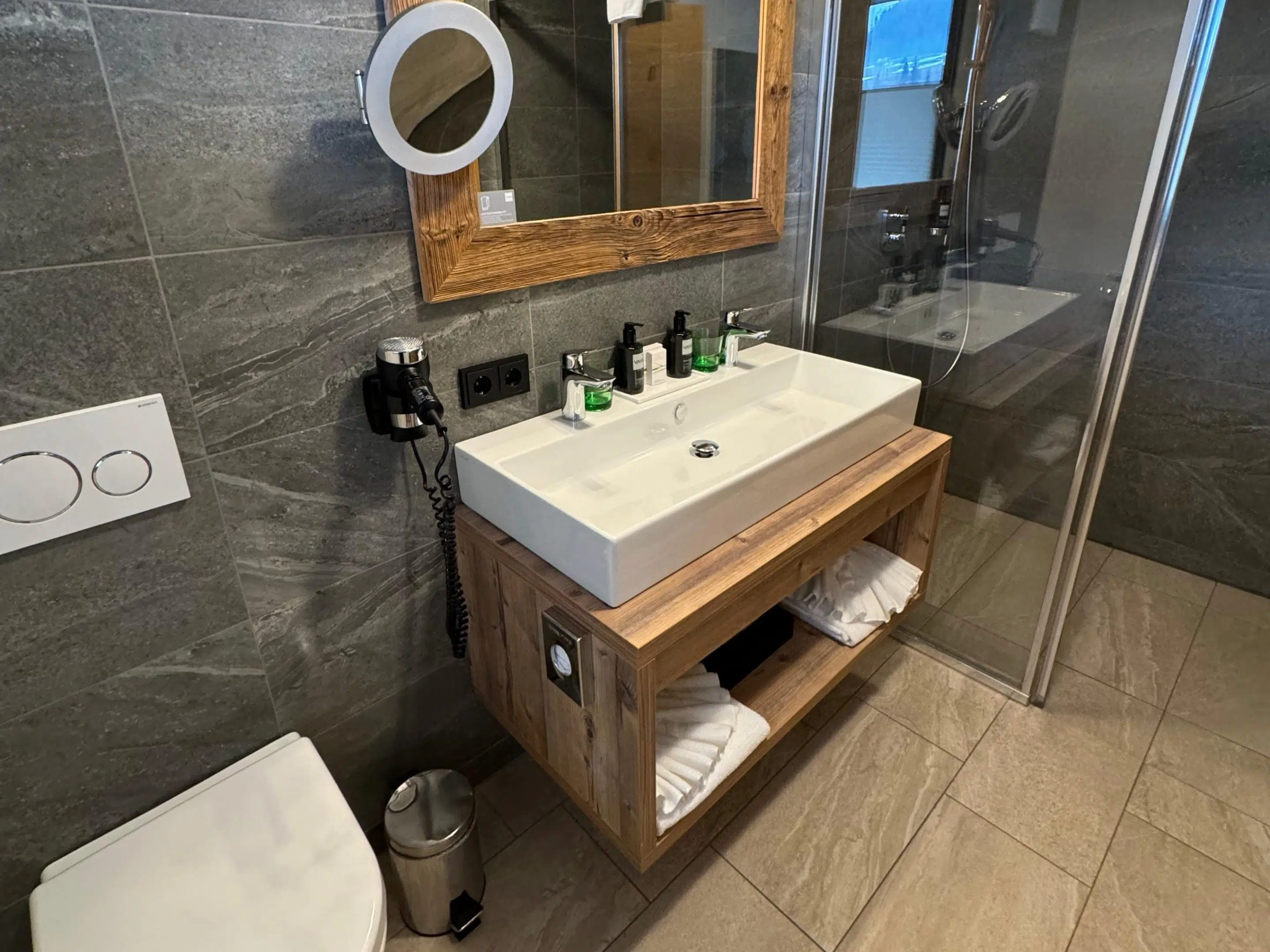 VAYA Fieberbrunn: Erfahrungen mit Zimmer, Spa & Lage 5 Modernes Badezimmer im VAYA Fieberbrunn mit Dusche und Holzwaschtisch