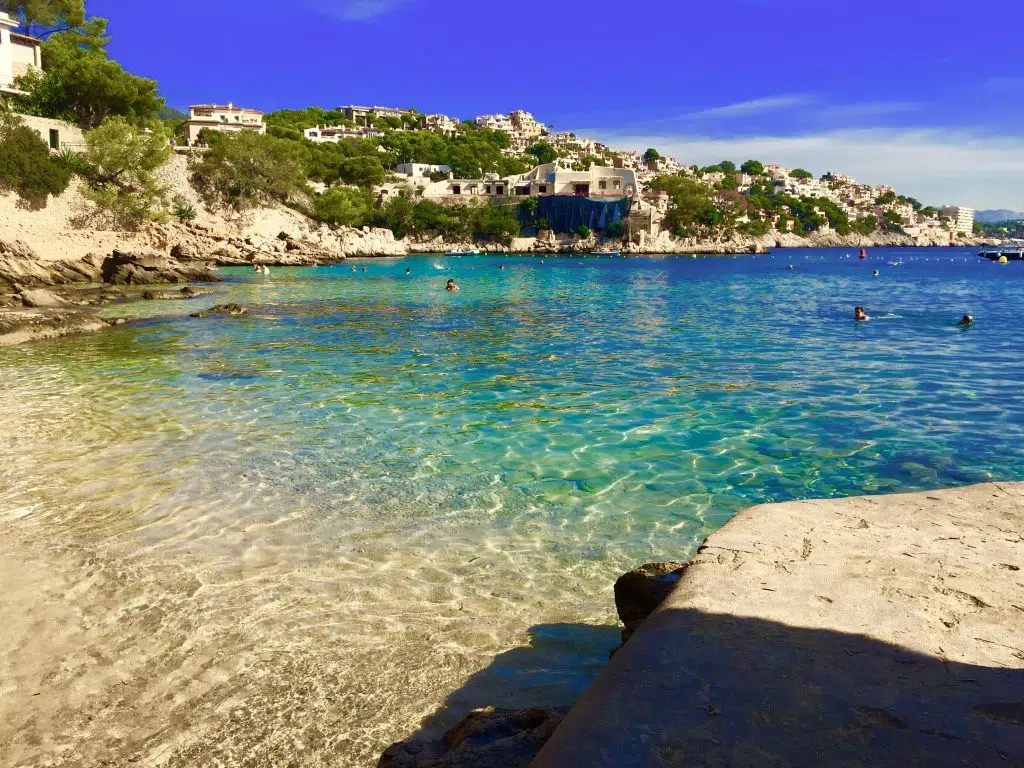 Hotel Cala Fornells auf Mallorca – meine Erfahrungen nach über 30 Jahren 3 Blick vom Strand auf das klare Wasser der Bucht Cala Fornells, Felsen und Häuser am Hang.