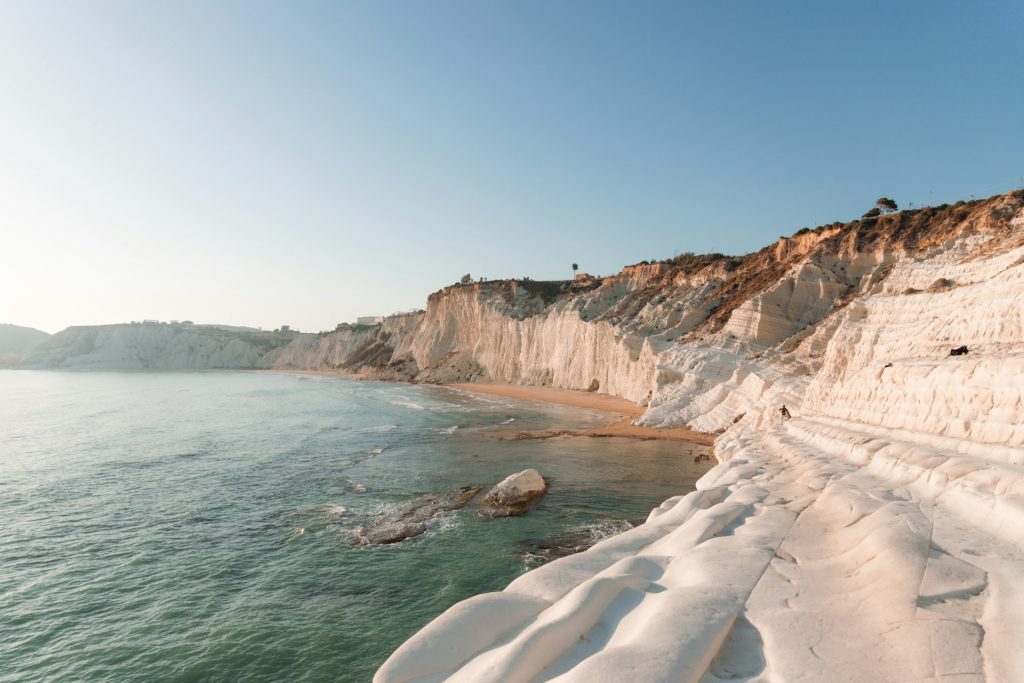 Es gibt Orte, die dich schon packen, bevor du sie überhaupt gesehen hast. Sizilien ist für mich so ein Ort. Die große italienische Insel ganz im Süden zieht mich in diesem Jahr magisch an. Palermo, wo die Geschichten aus griechischer Antike, arabischer Pracht und italienischer Wildheit noch zwischen den Fassaden widerhallen. Das Tal der Tempel in Agrigent, das bei Abendlicht wirkt, als würde der Sand die Zeit konservieren. Und die Küstenstraßen bei Cefalù, auf denen jede Kurve ein neues Blau freilegt. Ganz ehrlich, Italien steht bei mir momentan so hoch im Kurs, dass ich sogar italienisch lerne. Das sind Emozioni pur!