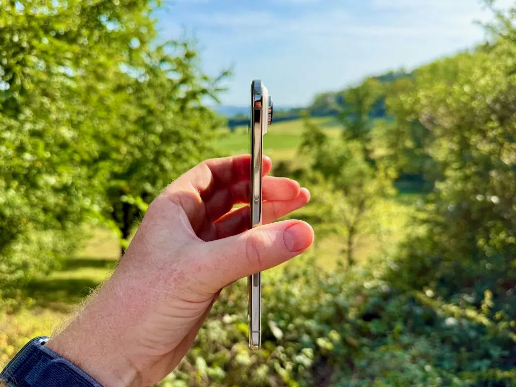 iPhone Air Test: meine Erfahrungen als Reise-Smartphone 1 iPhone Air in Seitenansicht in einer Hand vor grüner Landschaft