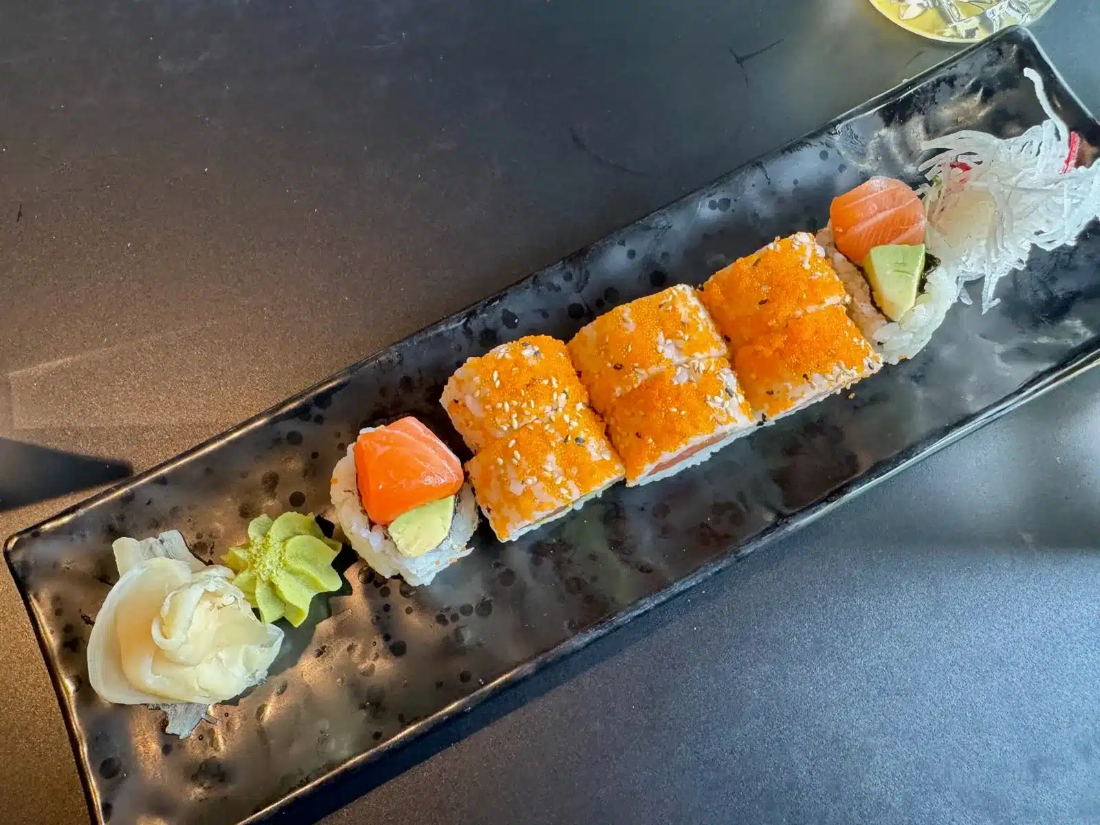 Koi Hameln Erfahrungen: mein Lieblingsasiate für Ente, Sushi und Curry 5 Sushirollen und Nigiri auf langer schwarzer Platte im Koi Hameln