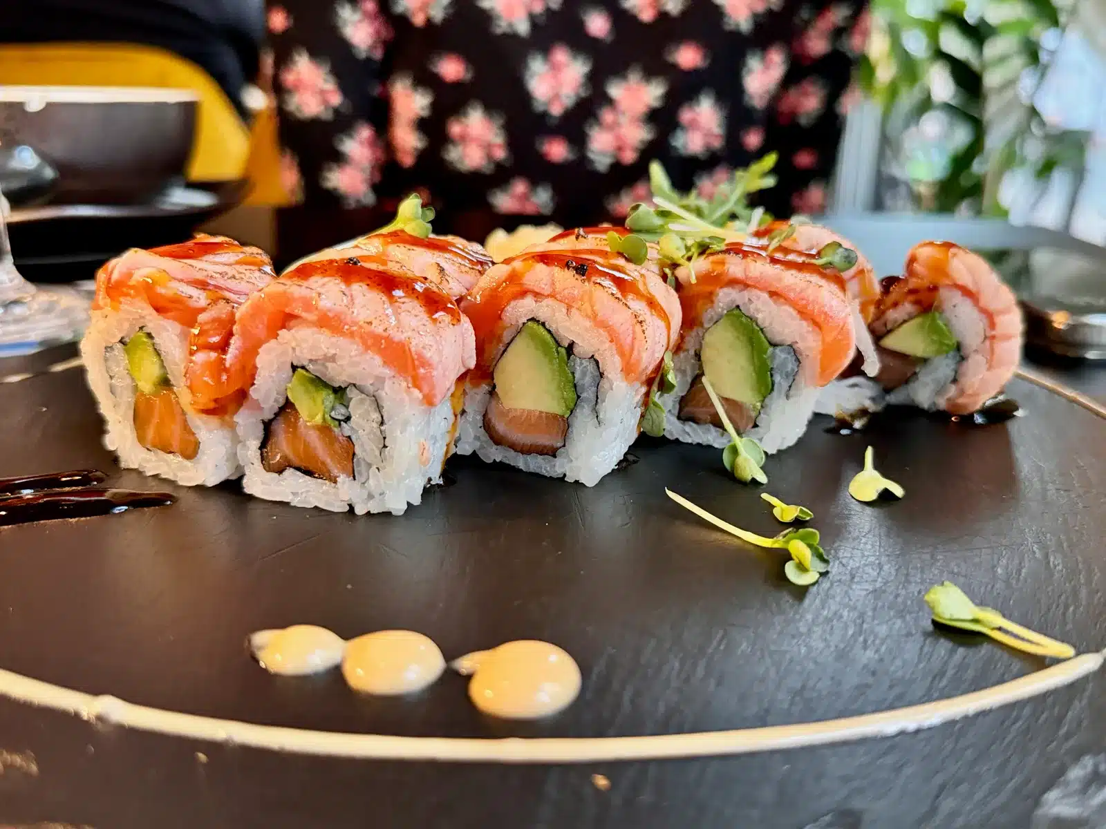 Sushirolle mit Lachs und Avocado auf schwarzem Teller im Koi Hameln