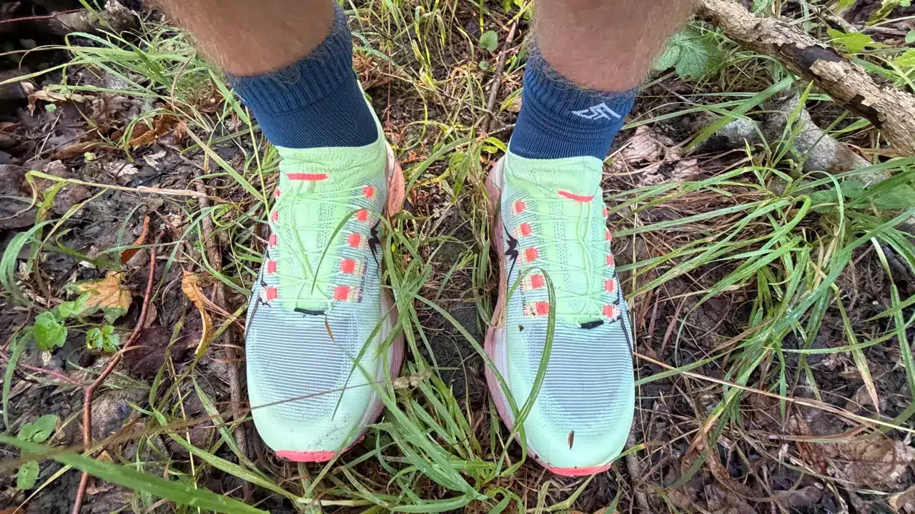 Asics Metafuji Trail 2 Test – meine Erfahrungen und der Vergleich mit dem Vorgänger 10 Asics Metafuji Trail 2 an den Füßen auf feuchtem Waldboden zwischen Gras, Ästen und Schlamm.