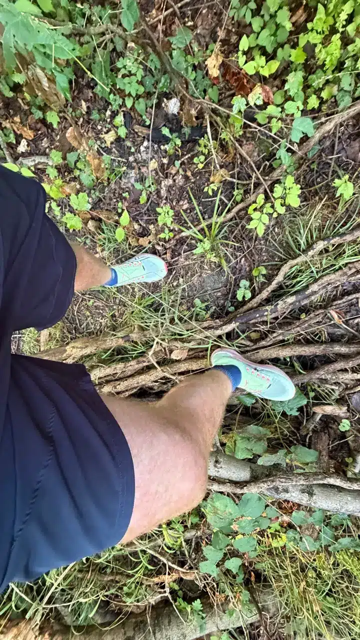 Asics Metafuji Trail 2 Test – meine Erfahrungen und der Vergleich mit dem Vorgänger 4 Asics Metafuji Trail 2 an den Füßen zwischen Ästen und Wurzeln auf nassem Waldboden.