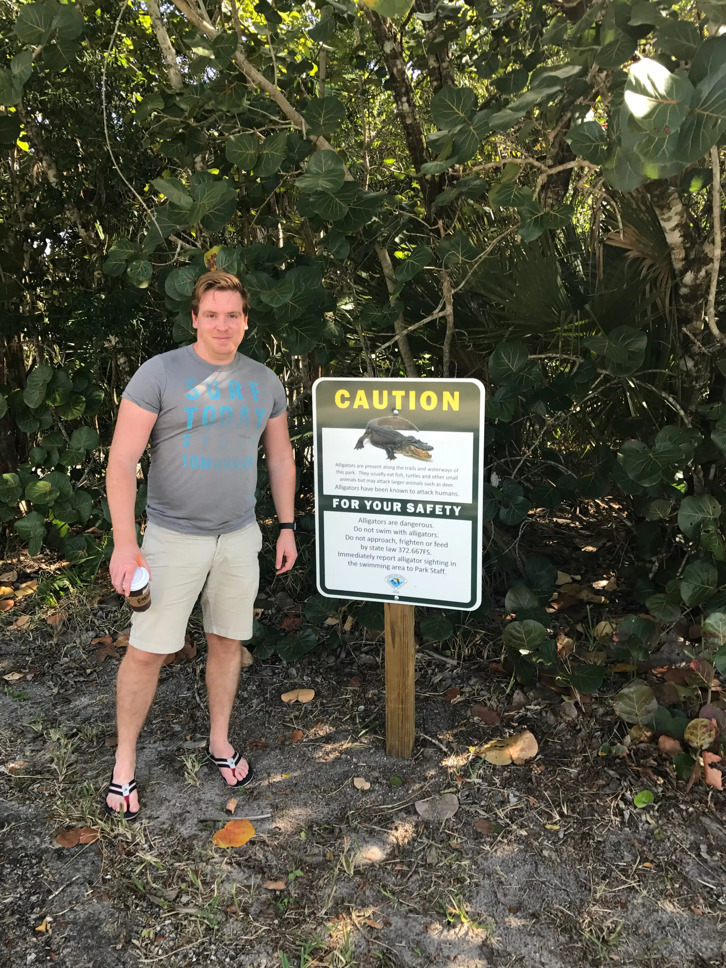 Everglades Erfahrungen: Alligatoren sehen ohne Airboat-Tour 6 Sascha Tegtmeyer neben einem Alligator-Warnschild vor dichter Vegetation