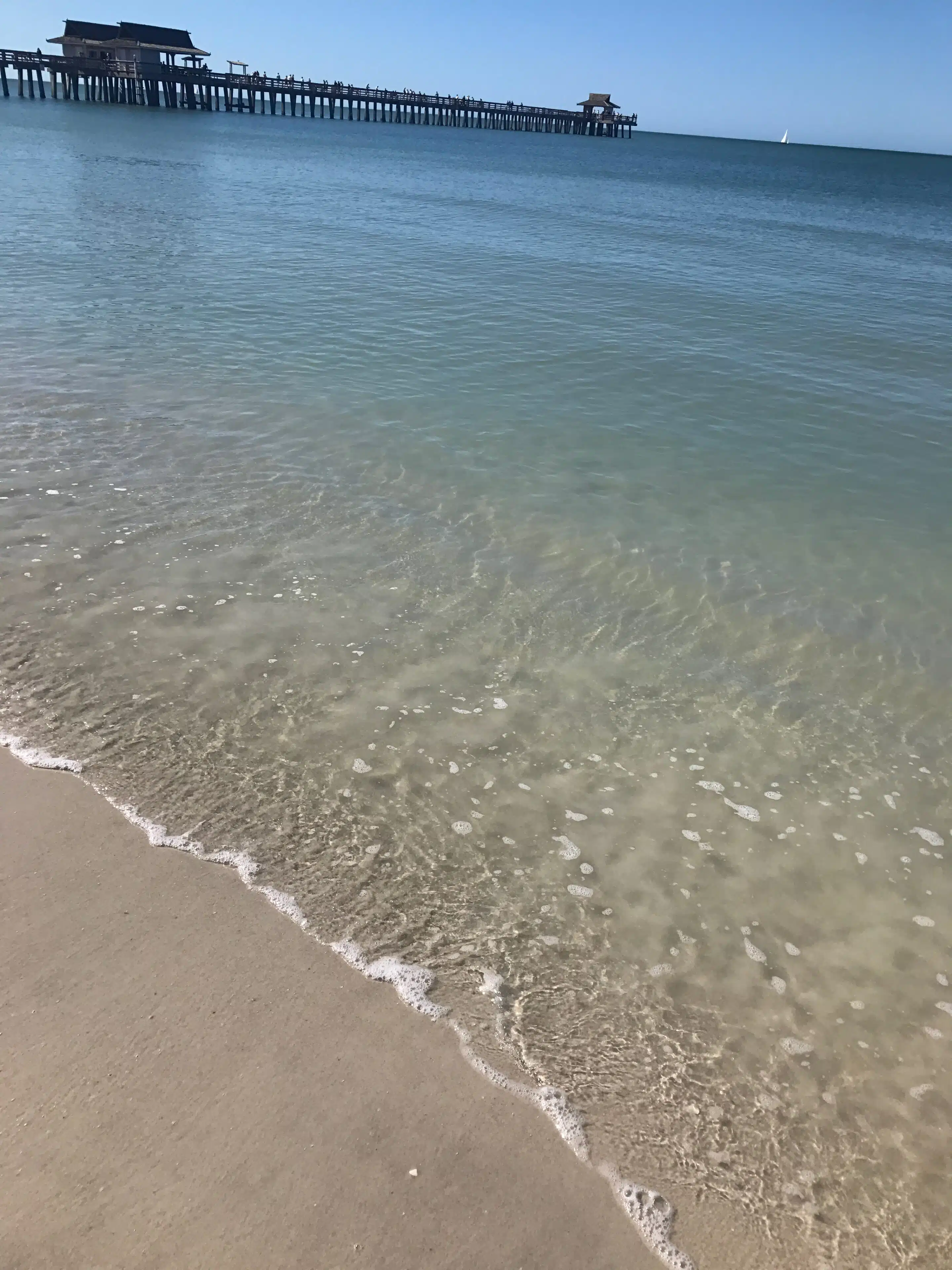Naples in Florida: Strand und Abendlicht am alten Pier 5 Wasserlinie und Sand vor dem langen Naples Pier bei Tageslicht