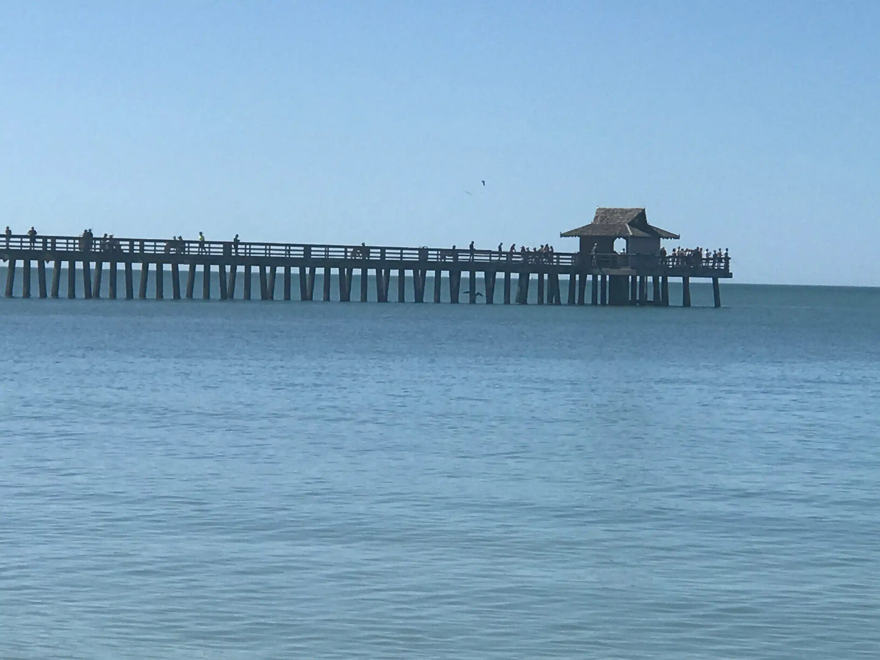 Naples in Florida: Strand und Abendlicht am alten Pier 6 Historische Seitenansicht des Naples Pierendes mit Besuchersilhouetten