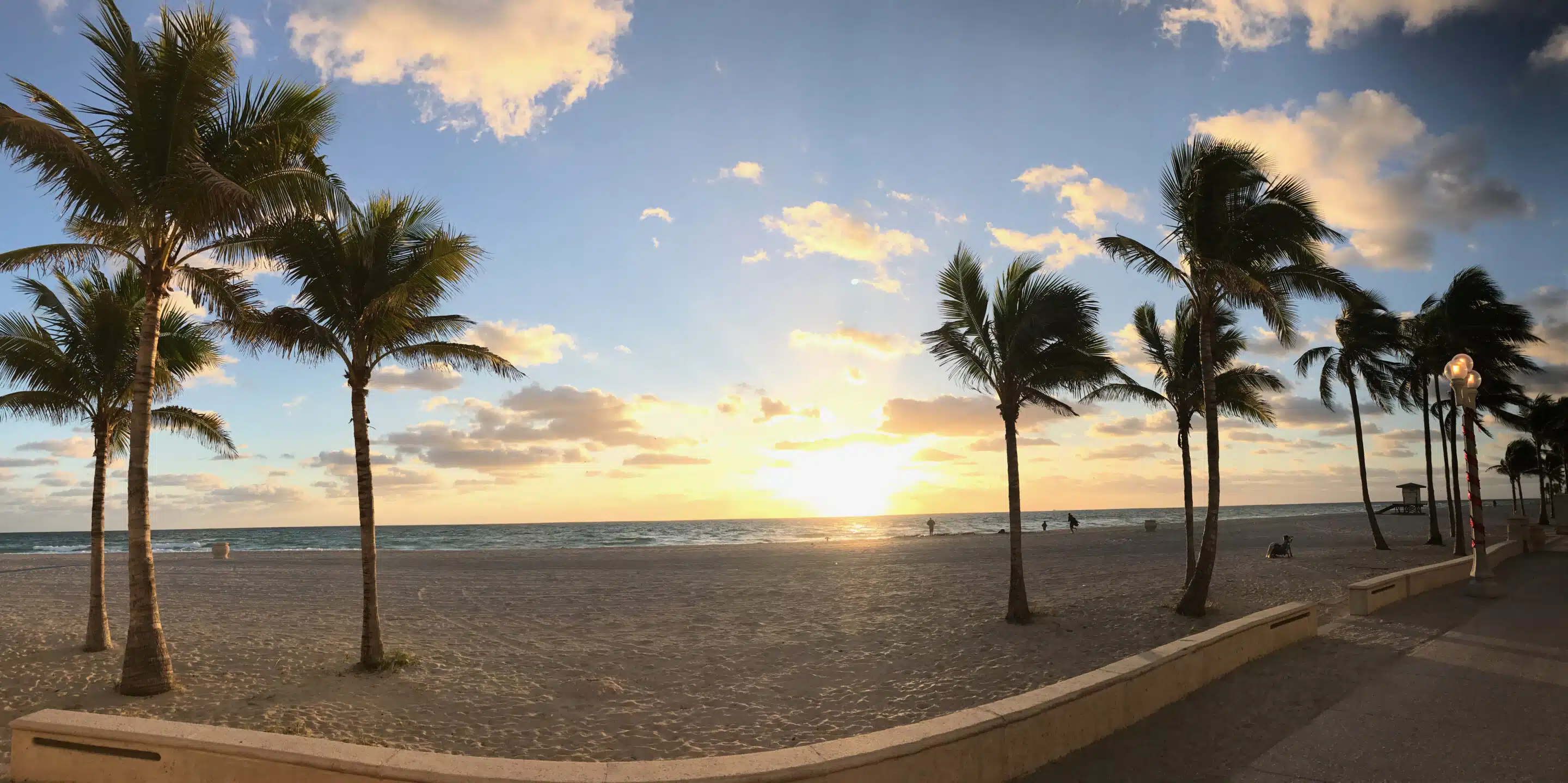 Florida-Rundreise: Zwischen Atlantik, Everglades und Golfküste 6 Strandpanorama mit Palmen im Morgenlicht und kleinen Personen in der Ferne