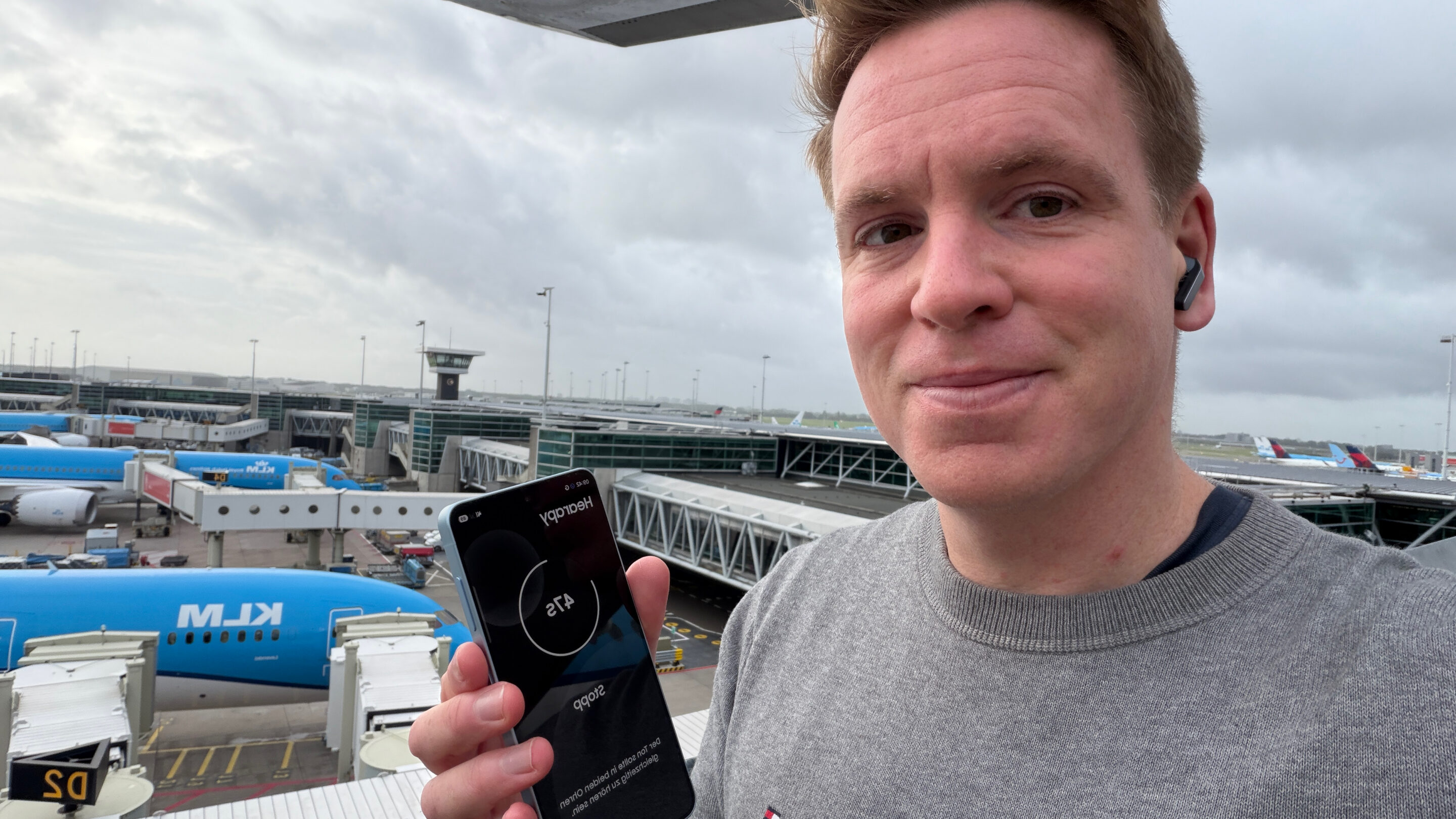 Samsung Galaxy S26 auf Reisen und im Outdoor-Einsatz: mein ehrlicher Praxistest 15 Sascha Tegtmeyer mit Hearapy auf dem Smartphone und Galaxy Buds am Flughafen Schiphol
