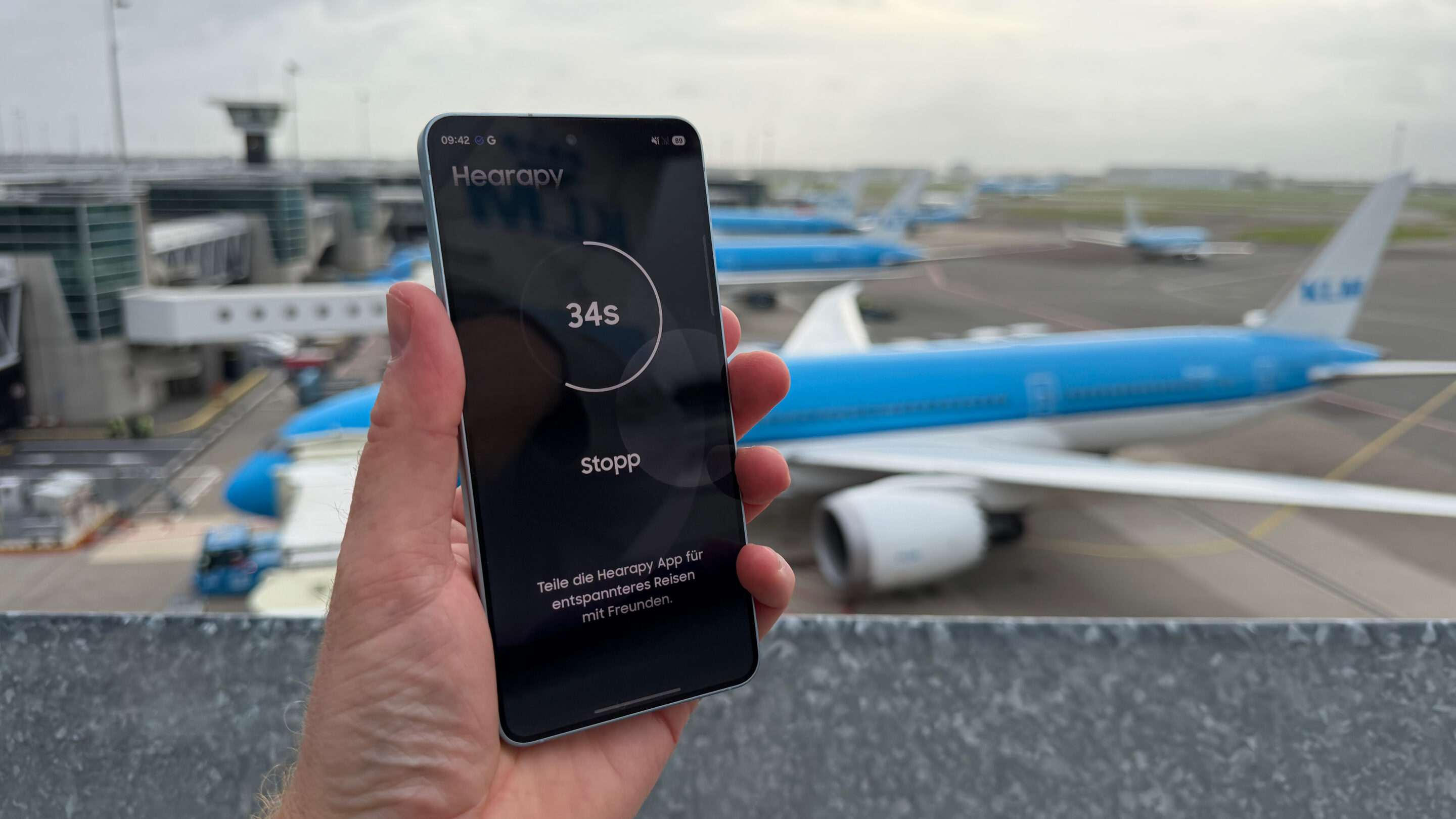 Samsung Galaxy S26 auf Reisen und im Outdoor-Einsatz: mein ehrlicher Praxistest 6 Hearapy-App mit laufendem Timer auf einem Samsung-Smartphone am Flughafen Amsterdam Schiphol