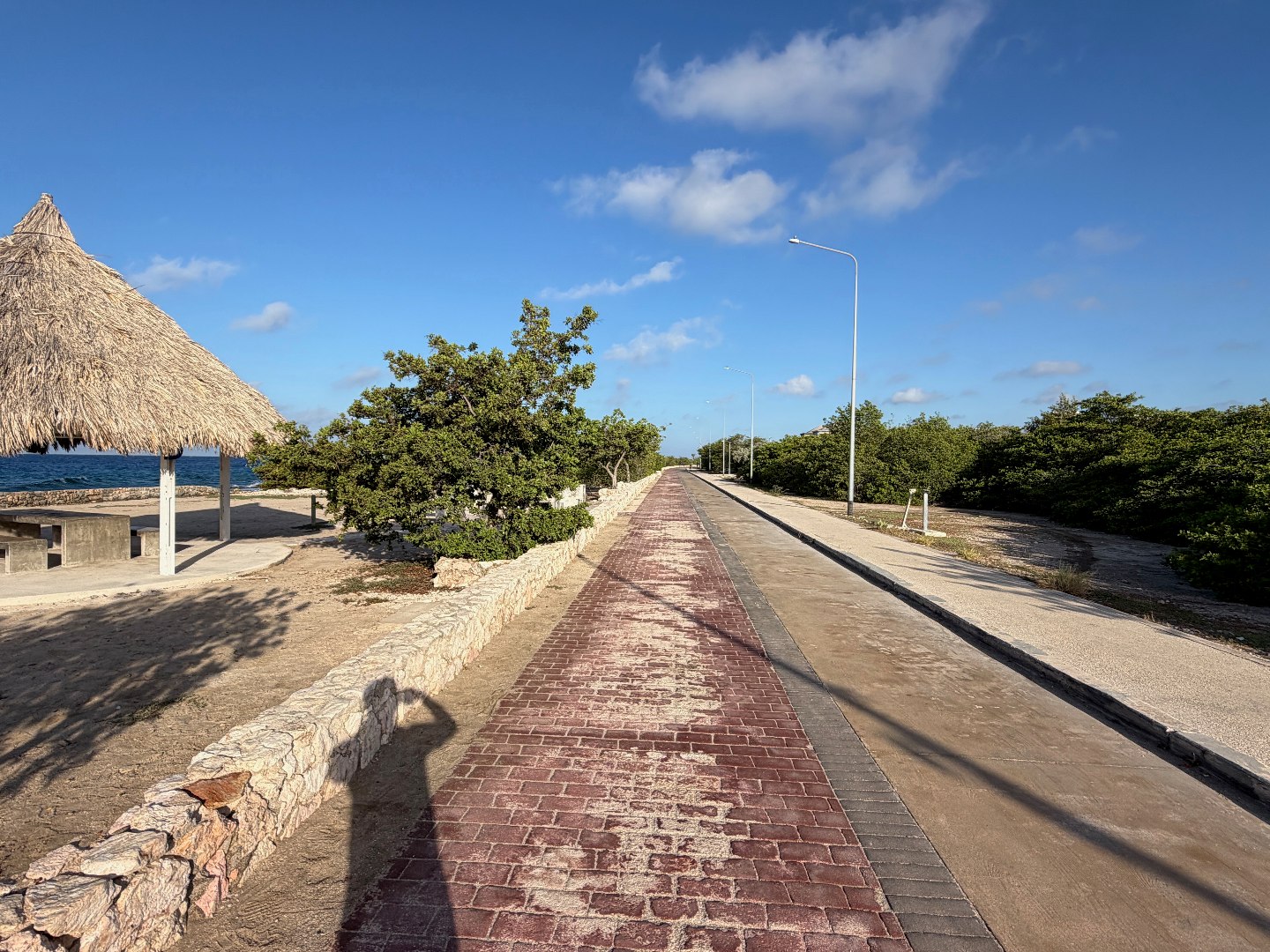 Digitale Reiseplanung mit KI: Was auf meiner Curaçao-Reise wirklich half 1 Gepflasterter Küstenweg zwischen Meer, Pavillon und Sträuchern auf Curaçao
