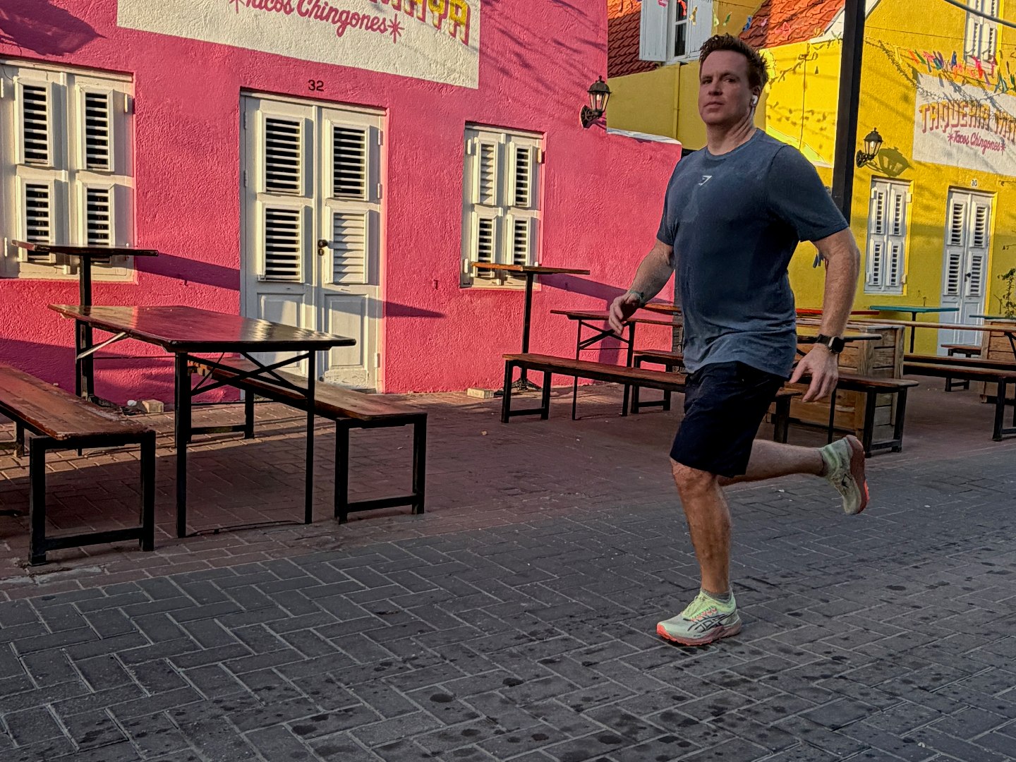 Meine Curaçao-Packliste: Was ich gebraucht habe – und was ich nächstes Mal ändere 1 Sascha Tegtmeyer läuft vor roten und gelben Häusern in Willemstad.
